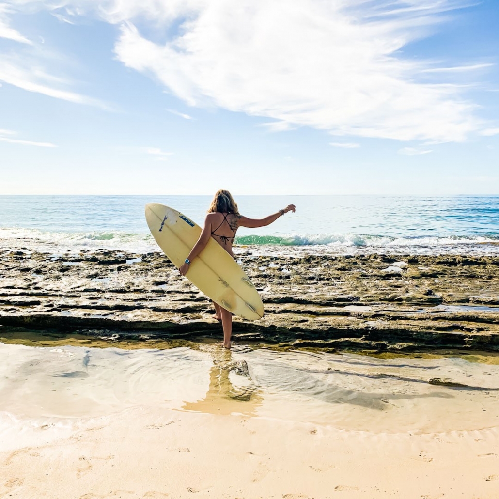 girl with surfboard under her arm