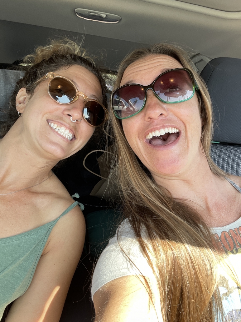 two girls inside the car take a selfie in sunglasses during a road trip up the coast of California