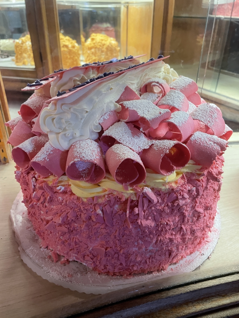 a bright pink champagne cake sprinkled with white powdered sugar at the Madonna Inn