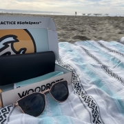 WoodRoze sunglasses sit on a sandcloud beach towel in Newport Beach, California