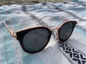 WoodRoze Angelinas sunglasses sit on a beach towel in Newport Beach, California